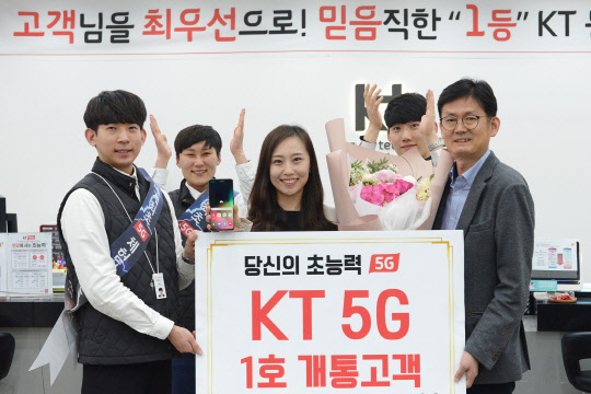 5G 1호 가입자 이지은씨가 대구 동성로 직영점에서 세계 첫 5G 스마트폰 '갤럭시 S10 5G' 개통 후, KT 직원들과 함께 기념촬영을 하고 있는 모습. KT 제공